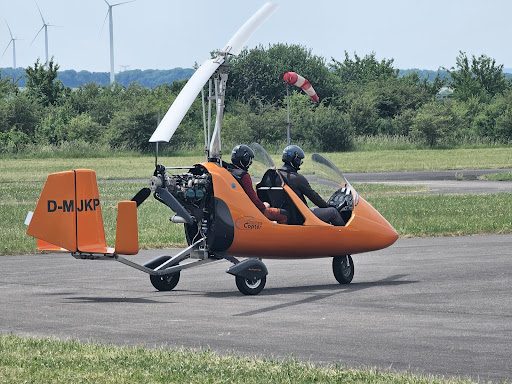 Tragschrauber mit zwei Personen rollt zur Startbahn